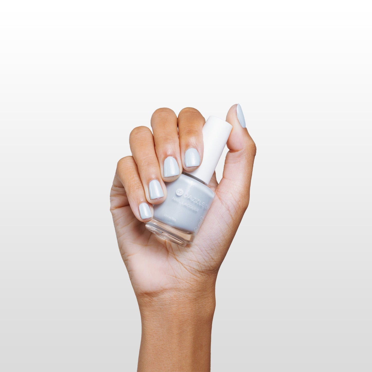 Hand with Moonlight painted on nails holding lacquer bottle