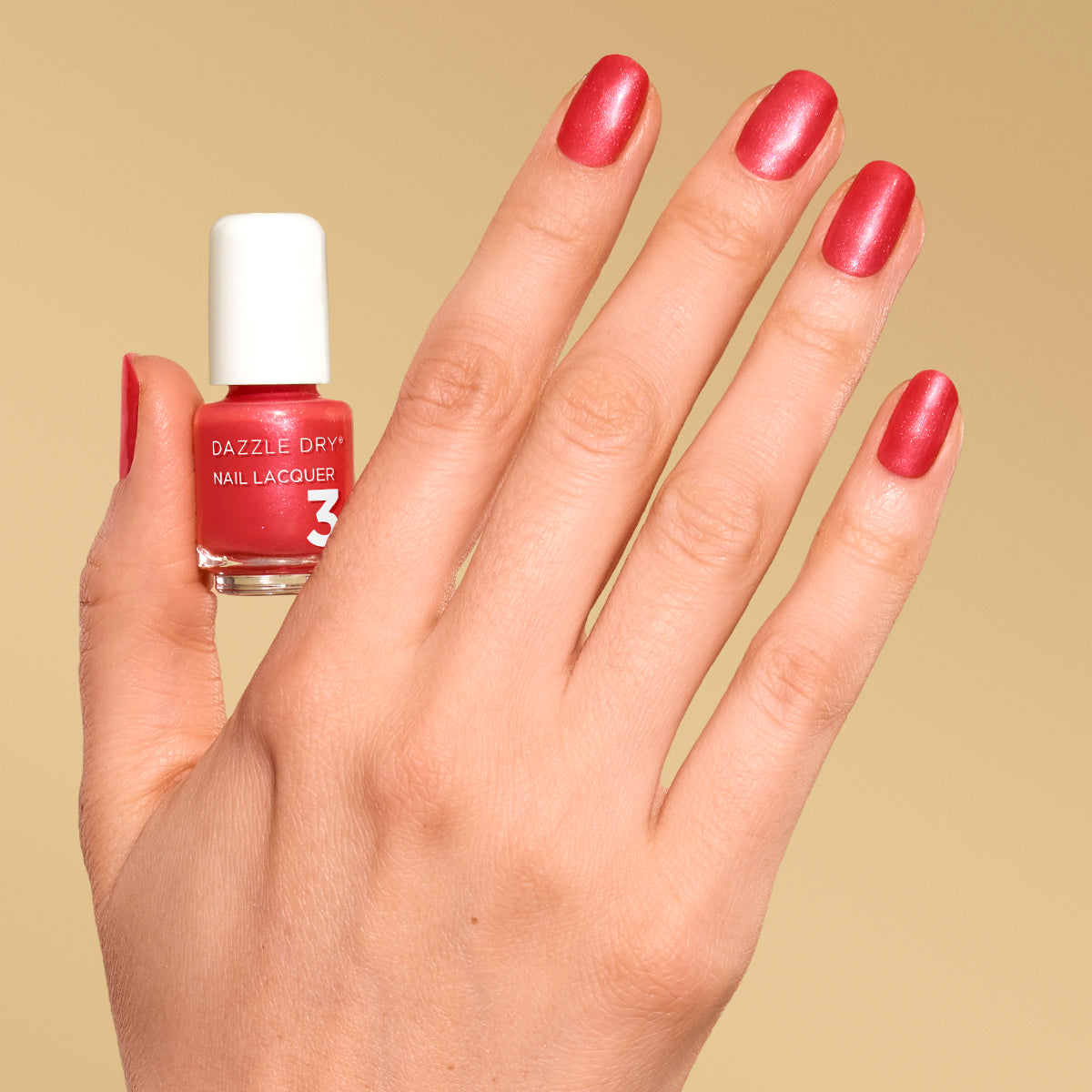 Hand with Poolside Pink painted on nails holding mini size lacquer bottle