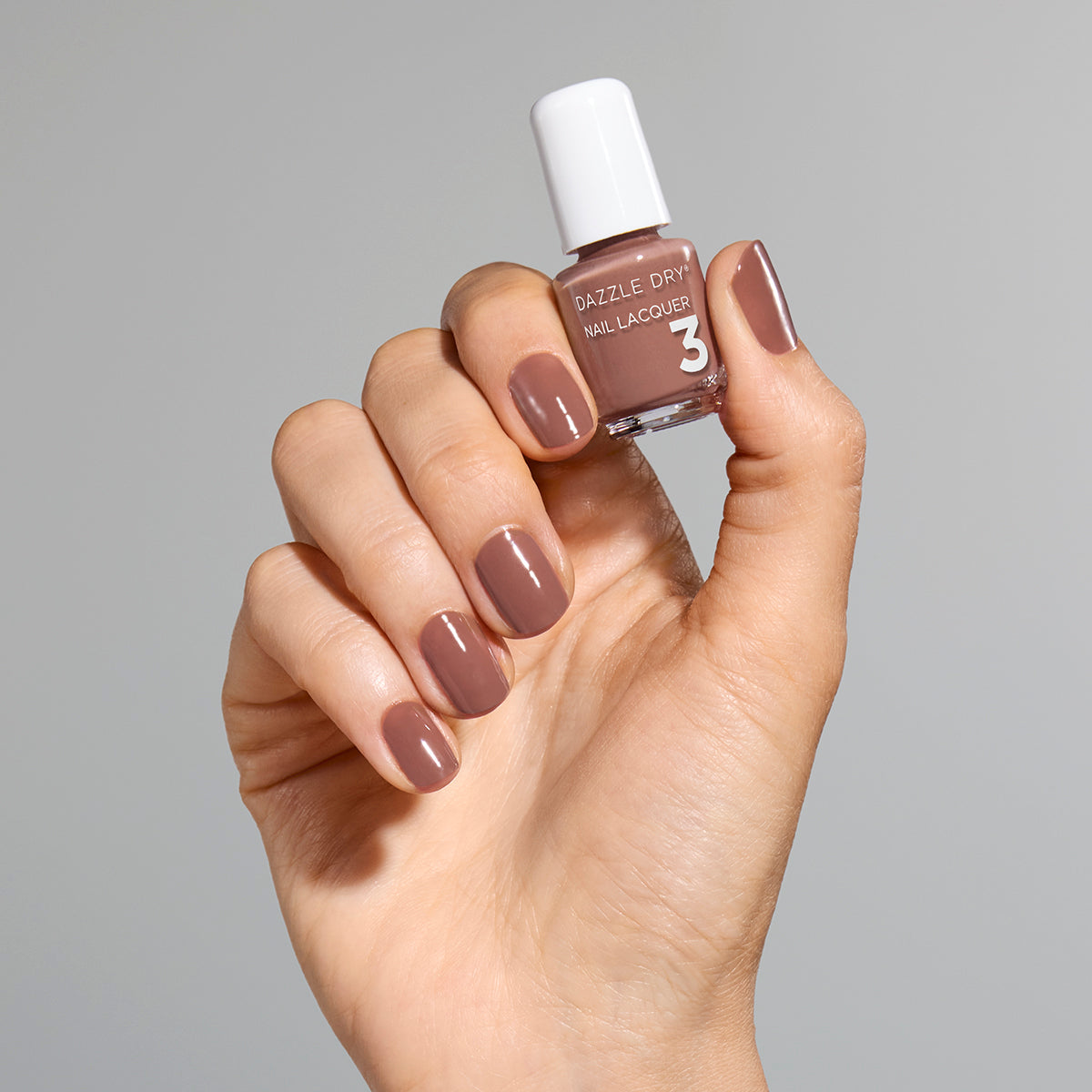 Hand with Your Nails, But Better painted on nails holding mini lacquer bottle