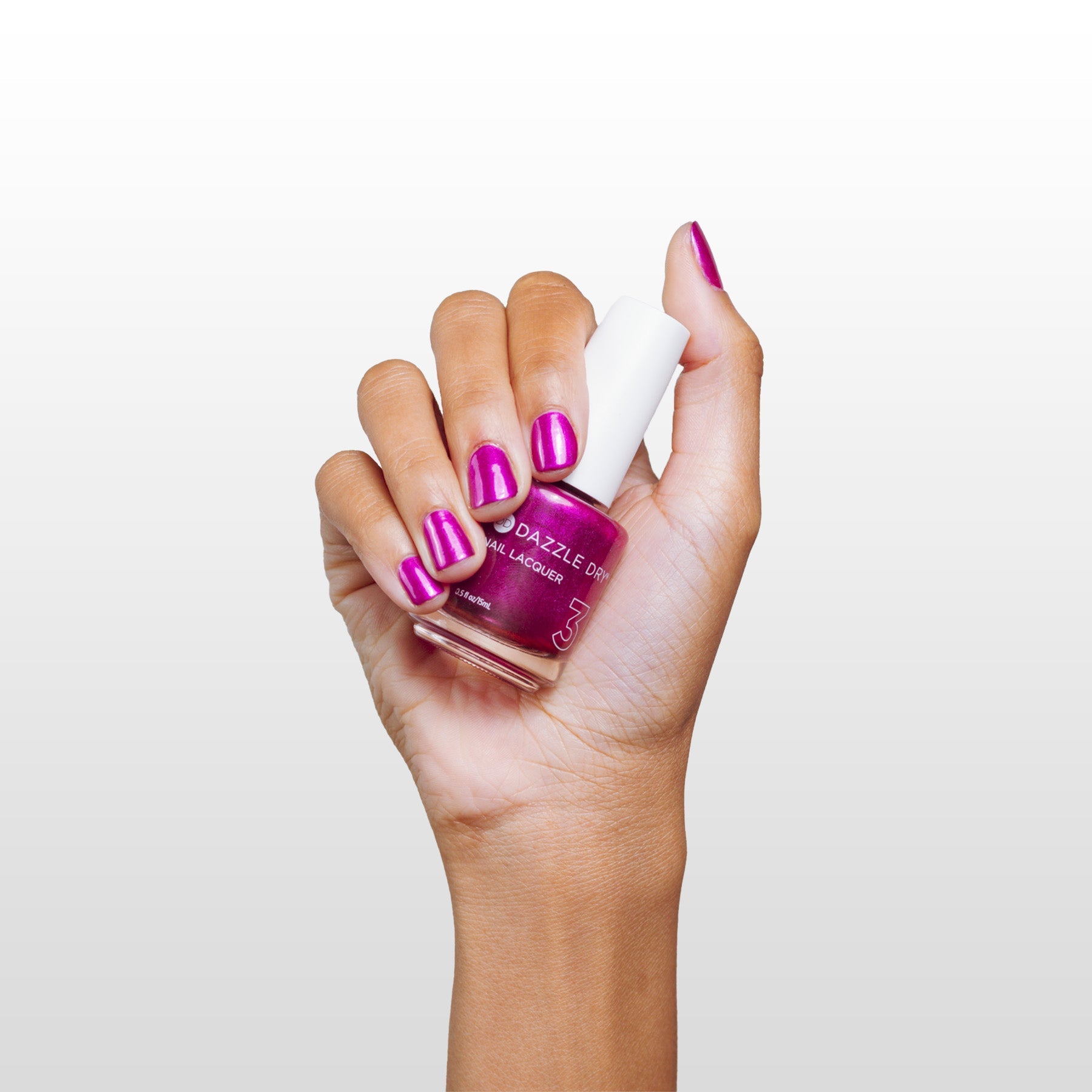 Hand with Kaleidoscope painted on nails holding lacquer bottle